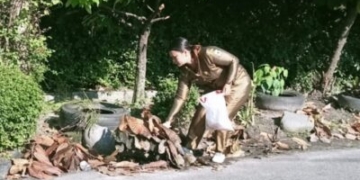Keterangan foto: Lurah Kahean Aprita Pronika Sagala Memungut sampah sebagai contoh buat warganya.