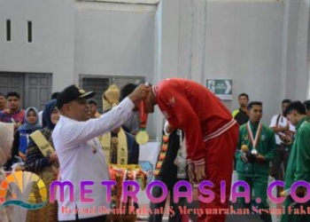 Teks Foto:Pj Bupati Aceh Timur Amrullah M. Ridha mengalungkan emas untuk Tim regu Putra Provinsi Sulawesi Selatan. Acara ini dikemas dalam upacara penyerahan medali yang dihelat di Gedung Idi Sport Center, Rabu 11/9.