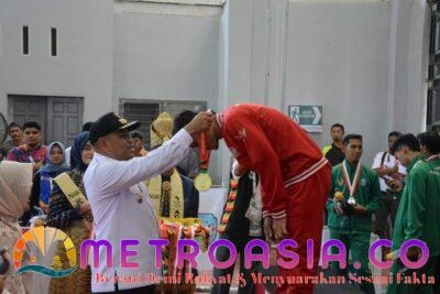 Teks Foto:Pj Bupati Aceh Timur Amrullah M. Ridha mengalungkan emas untuk Tim regu Putra Provinsi Sulawesi Selatan. Acara ini dikemas dalam upacara penyerahan medali yang dihelat di Gedung Idi Sport Center, Rabu 11/9.